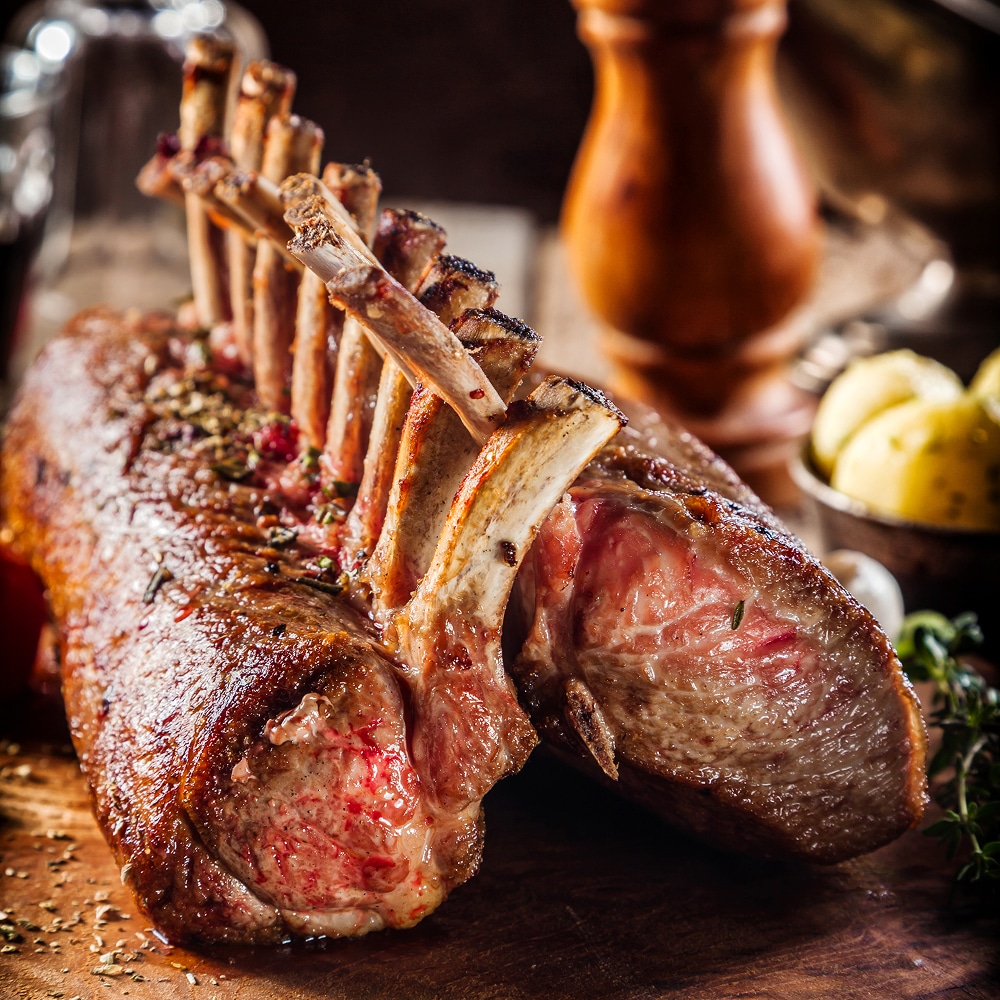 Ambiance chaleureuse dans notre salle de restaurant bistro Intérieur de restaurant décoré murs turquoise et rouge, chaises bois, et tables dressées. Un comptoir buffet est visible au fond.