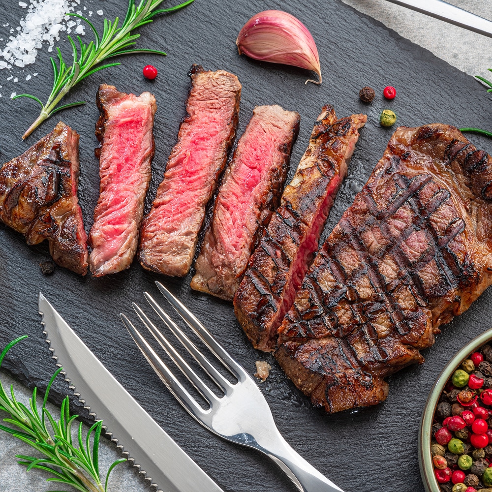 Ambiance chaleureuse dans notre salle de restaurant bistro Intérieur de restaurant décoré murs turquoise et rouge, chaises bois, et tables dressées. Un comptoir buffet est visible au fond.